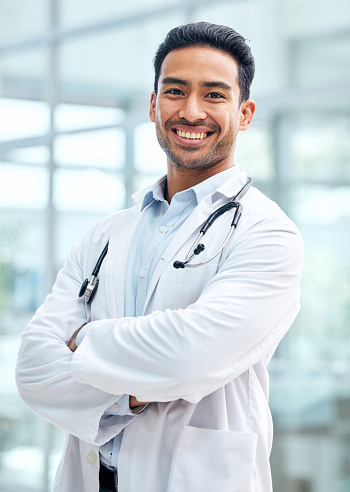 Portrait of doctor with smile, confidence and hospital employee with care, support and trust. Health insurance, happy man and medical professional with arms crossed in healthcare career for advice.