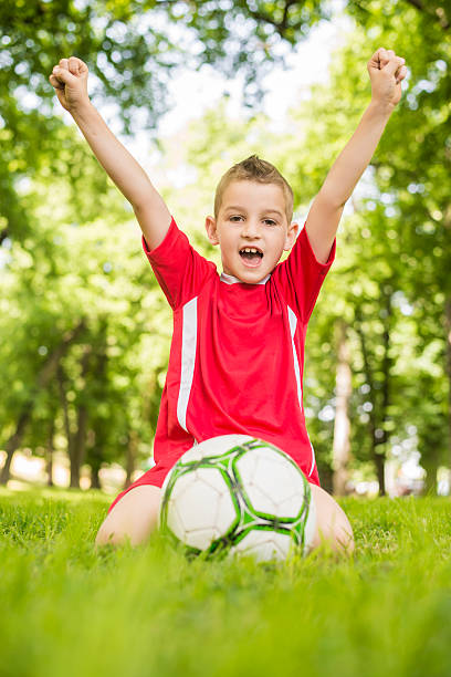 istock A young boy playing soccer with his arms raised 178592422