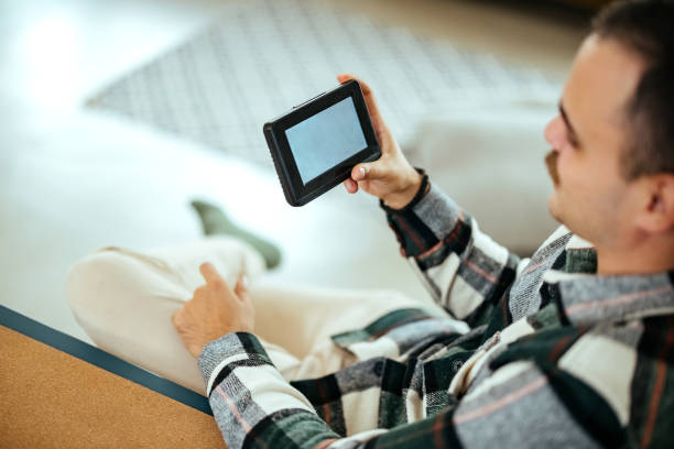 istock Man holding a smartphone with smart home screen. 1785931237