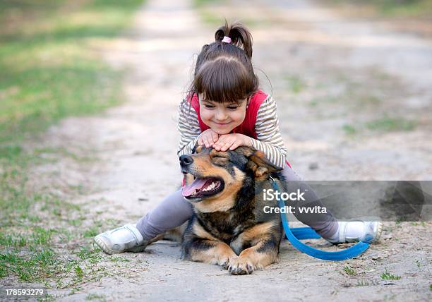 Foto de Menina Feliz Brincando Com Cachorro e mais fotos de stock de Amizade - Amizade, Animal de estimação, Animal doméstico