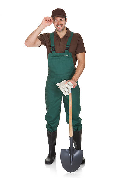 Happy young gardener in dungarees. Isolated on white