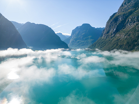 Sunny day with some clouds, reflection on the water surface, top of a mountain pass.