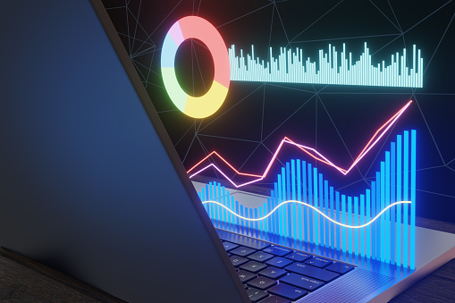 Glowing bar charts, pie chart and line graphs in hologram on a laptop. Illustration of the concept of stock trend analysis