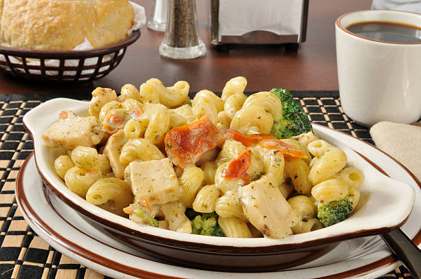 Chicken with basil parmesan sauce on pasta A bowl of chicken with basil parmesan sauce on cavatappi pasta broccoli crowns stock pictures, royalty-free photos & images