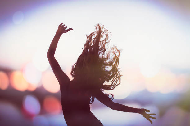 Silhouette of a dancing girl and bokeh.