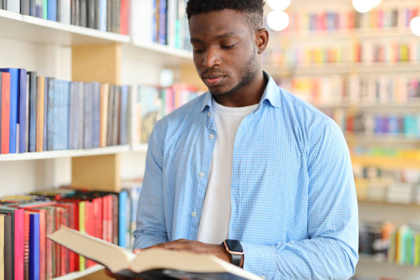istock A serious and focused young man studying in a library, surrounded by books and bookshelves, showcasing a commitment to education and learning. 1785967680