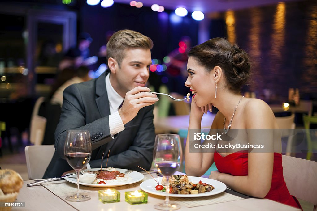 man feeding woman Affectionate couple in restaurant,  him feeding she Dinner Stock Photo