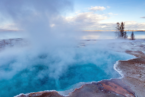 Steam coming from the Black Pool hot spring in the West Thumb Geyser area of Yellowstone Lake in Yellowstone National Park at sunset.