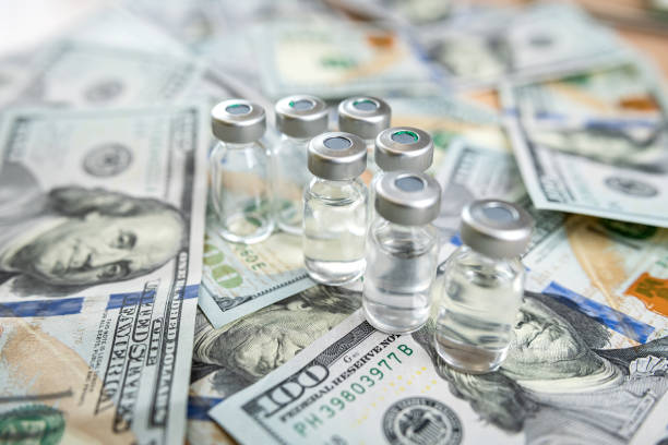 istock COVID-19 or other vaccine in bottle on dollar bills background 1785977706