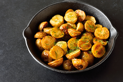 Roasted potatoes in frying pan, close up view