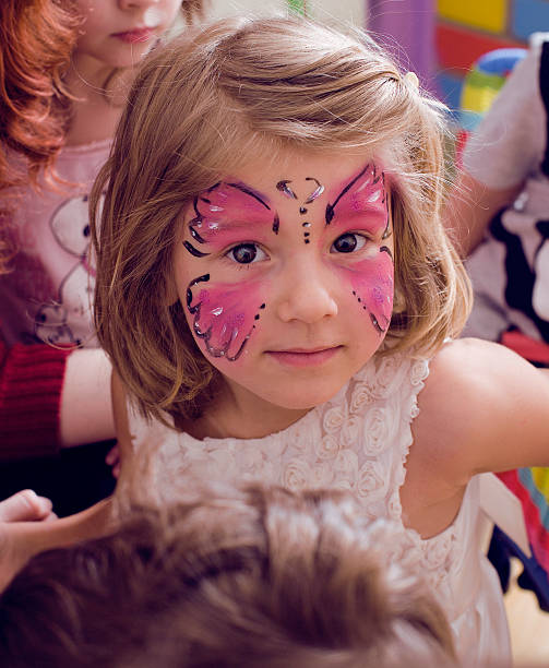 little girl with faceart on birthday party stock photo