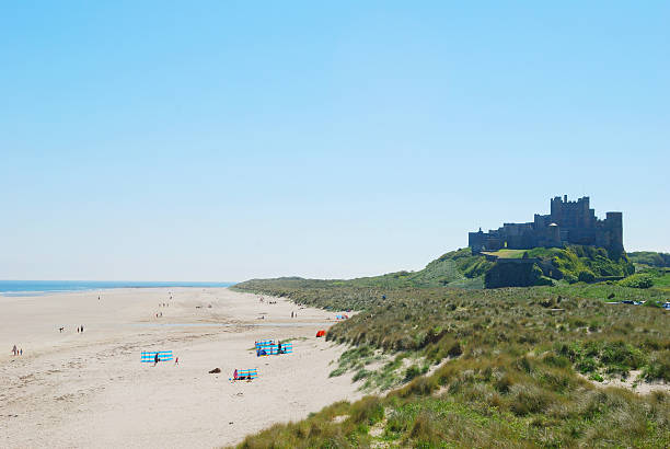 castello di bamburgh e spiaggia in nebbia estate giorno - bamburgh foto e immagini stock