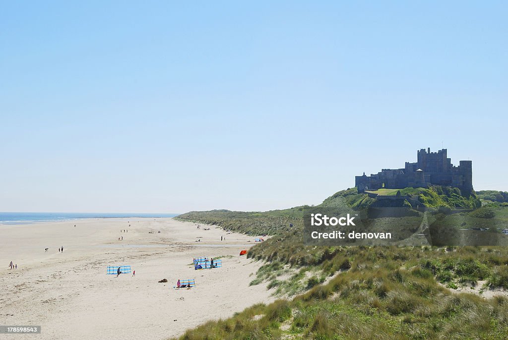 Bamburgh castle and beach on hazy summer day Bamburgh castle and beach on a hazy summer day Bamburgh Stock Photo