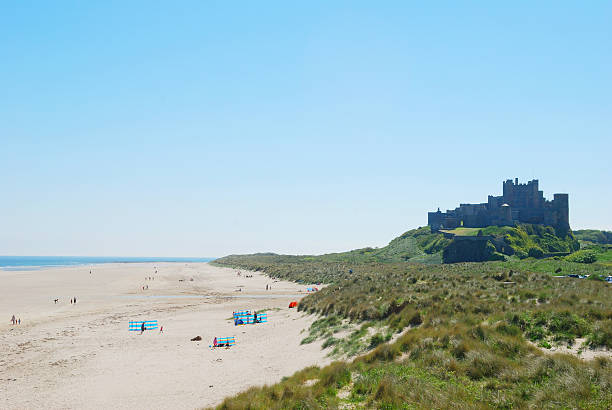 Bamburgh castle and beach on hazy summer day stock photo