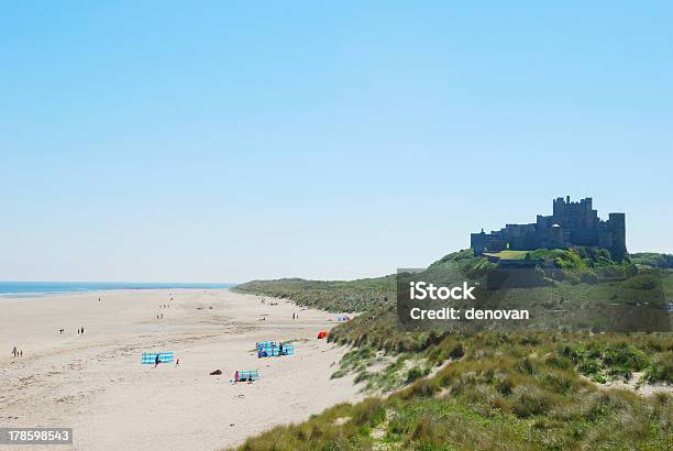 Bamburgh Castle And Beach On Hazy Summer Day Stock Photo - Download Image Now - Bamburgh, Beach, Blue