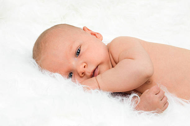 Newborn cute baby boy lying on fur blanket stock photo