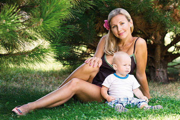 Belle femme avec un enfant assis sur l'herbe - Photo