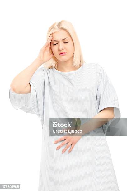 Young Female Patient In A Pain Stock Photo - Download Image Now - Hospital Gown, Studio Shot, Abdomen