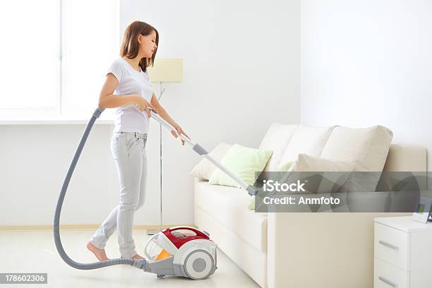 Attractive Girl Vacuuming A White Couch Stock Photo - Download Image Now - Vacuum Cleaner, Sofa, Women