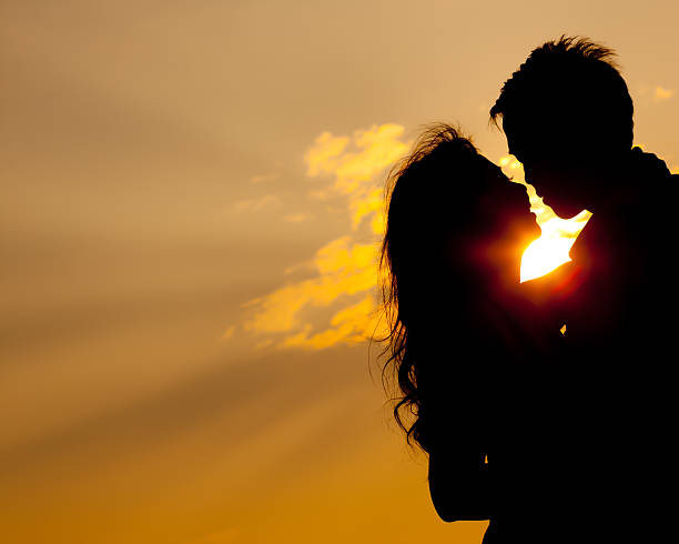 istock A couple hugging each other in front of the sun 178603373