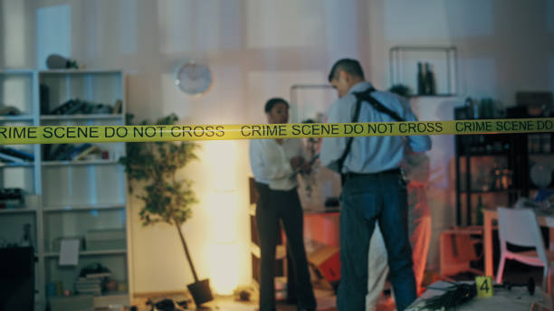 istock Two detectives conducting a murder investigation at a crime scene secured with tape 1786035922