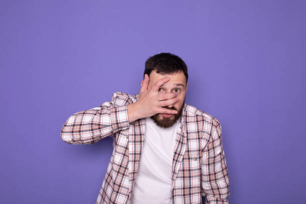 istock Young handsome bearded man feeling terrified, backing off and screaming in horror and panic, reacting to a nightmare on purple background. 1786038187