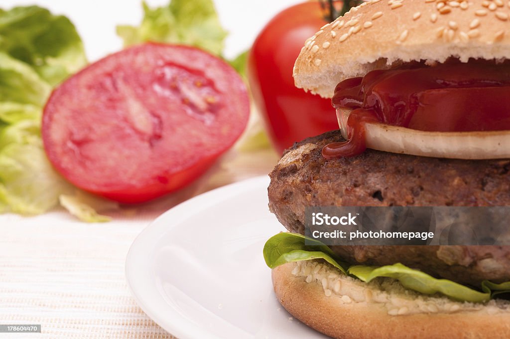 Ketchup on a Hamburger with beef Ketchup on a Hamburger with beef, tomato and onion Beef Stock Photo