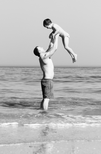 Happy father and son on the beach. black and white photo. Touching relations of the father and the boy with the syndrome of autism.