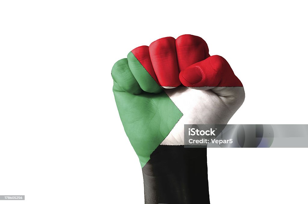 Fist painted in colors of sudan flag Low key picture of a fist painted in colors of sudan flag Aggression Stock Photo