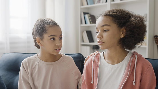 Upset teenage girl sharing bad news with best friend, supportive communication