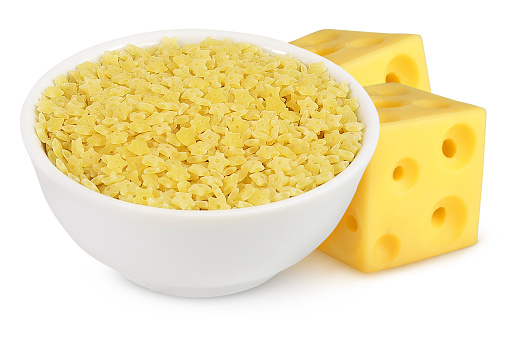 Pasta in a white bowl and cheese with holes on an isolated background.