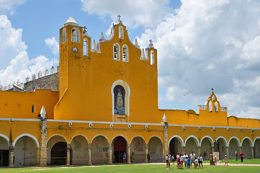 Izmal, Mexico - July 19, 2023: Colorful colonial style buildings at street of Izmal city old town, Mexico