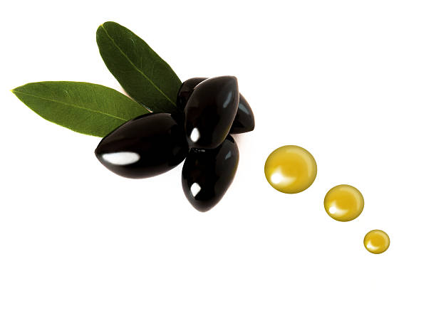 Several black olives with oil drops stock photo