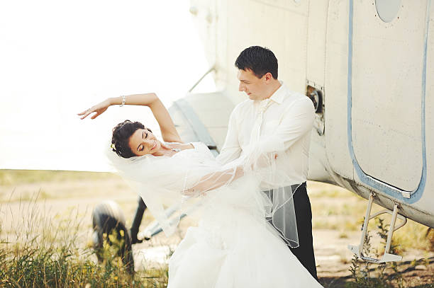 istock young caucasian wedding couple next to airplane 178607144