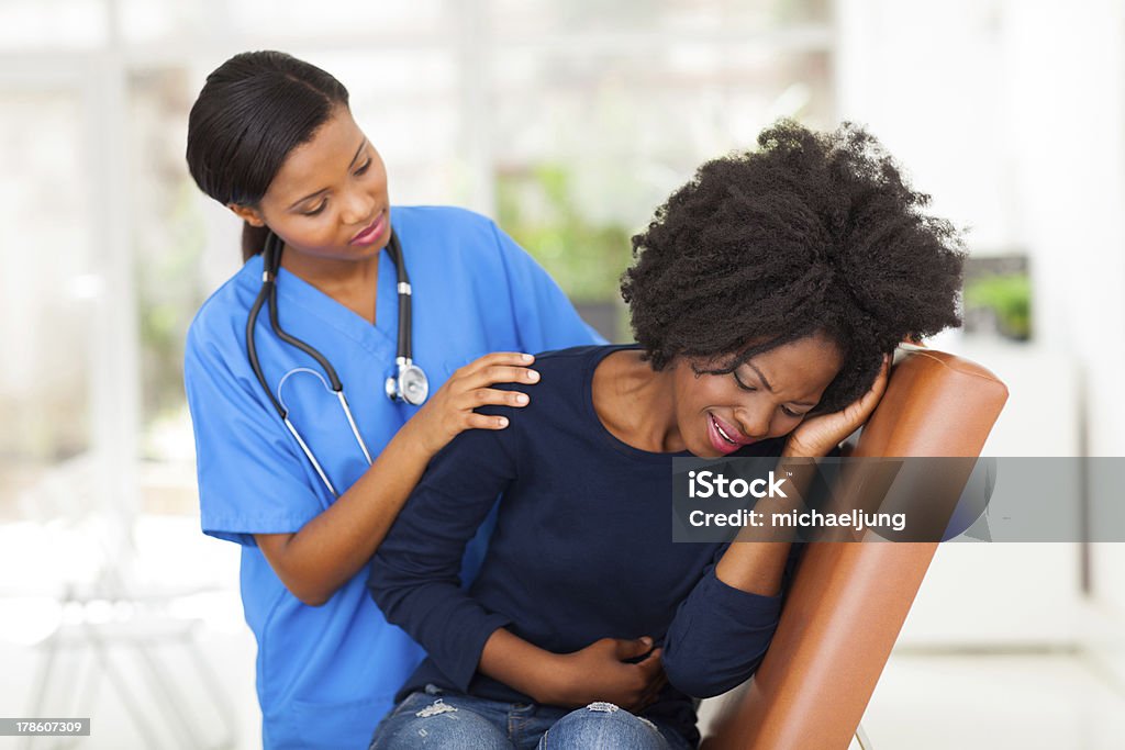african female medical worker comforting a sick patient african female medical worker comforting a sick patient in hospital Patient Stock Photo