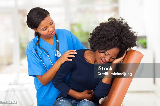 African Female Medical Worker Comforting A Sick Patient Stock Photo - Download Image Now