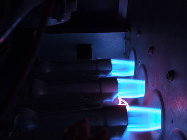 Inside a Natural Gas Furnace Three natural gas burners with bright blue flames inside an operating gas furnace. furnace photos stock pictures, royalty-free photos & images