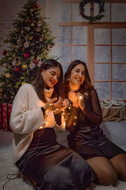 istock two women in front of a christmas tree holding sparklers 1786079957