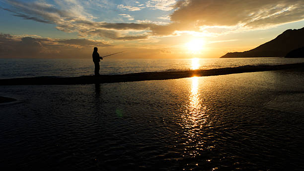 istock Fisher man with fishing rod silhouette 178608058