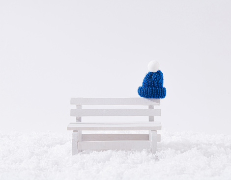 A blue winter cap left on the bench. Copy space. Front view.