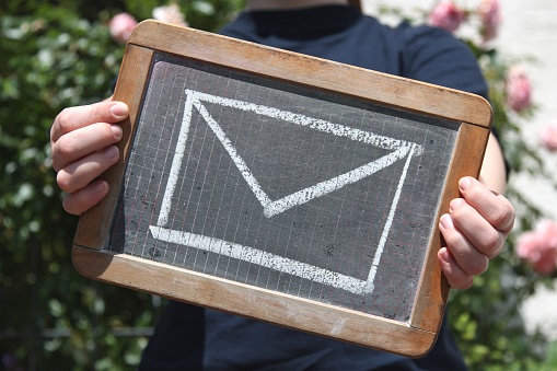 envelope sketched with chalk on slate shown by young female