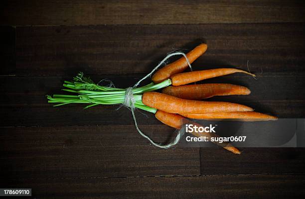 Carrots With Greens Tied On Brown Wood Stock Photo - Download Image Now - Adulation, Agriculture, Antioxidant