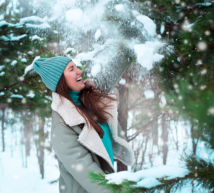 Outdoor close up portrait of young beautiful happy smiling hipster girl, wearing stylish poncho and fake fur hat.