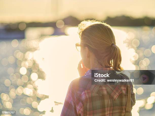 Thoughtful Woman Looking At Lake With Bokeh Reflections Stock Photo - Download Image Now