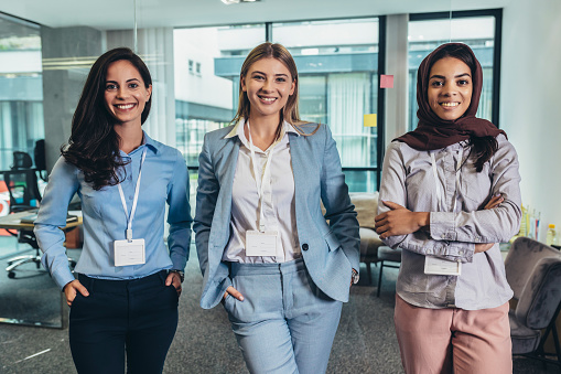 Group of modern multicultural young business women and business man in casual wear in the creative office.