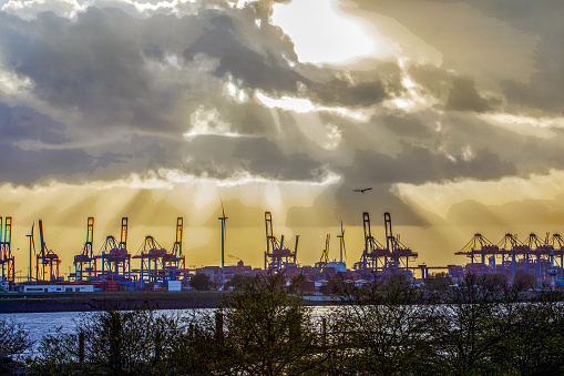Amazing sky over shipyards in Hamburg on Norderelbe river. Sunset time