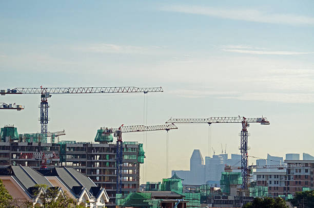 The skylines at many growing asian cities are ever-changing with new buildings constantly being erected. This photo was taken in Singapore. You can see the downtown business district in background and construction of new buildings in the foreground which will eventually block the view of downtown. Large cranes are used which add to the skyline.