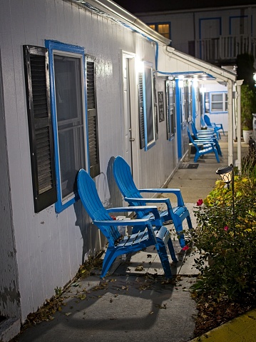 Vintage Mom and Pop style motel building with blue chairs to relax in out front. Traditional americana hotel in Williamstown Massachusetts.