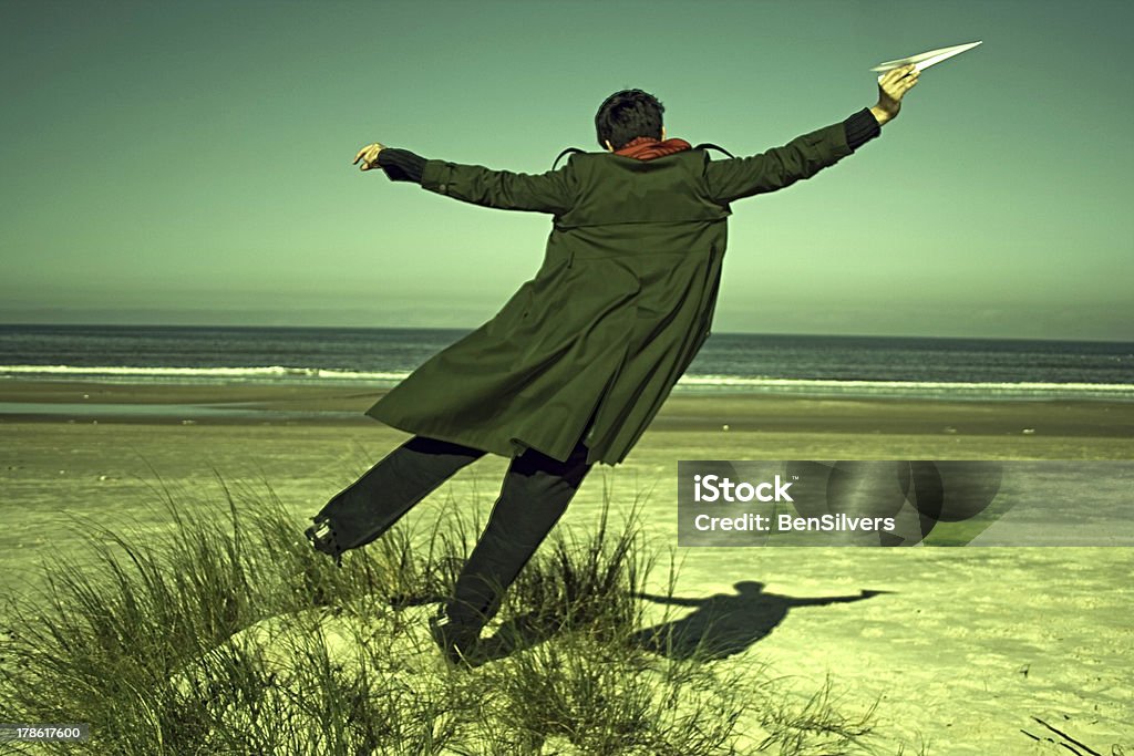 Hombre joven con papel avión en la playa - Foto de stock de Avión de Papel libre de derechos