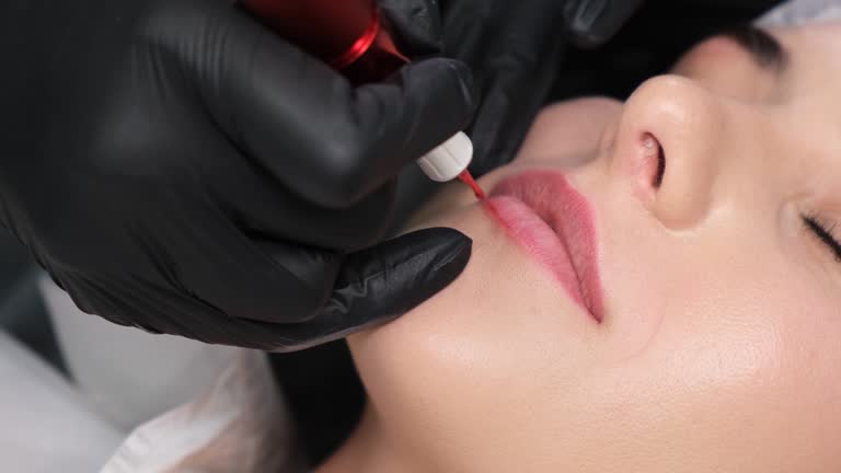 Young woman undergoing procedure of permanent lip makeup in salon, closeup